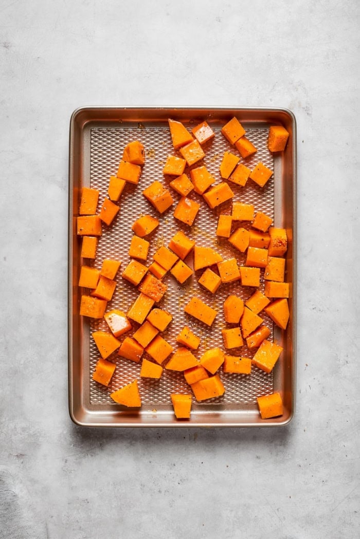 chopped butternut squash on a roasting pan