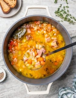 Ladle of ham and bean soup held over pot.