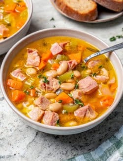 Bowl of ham and bean soup with spoon.