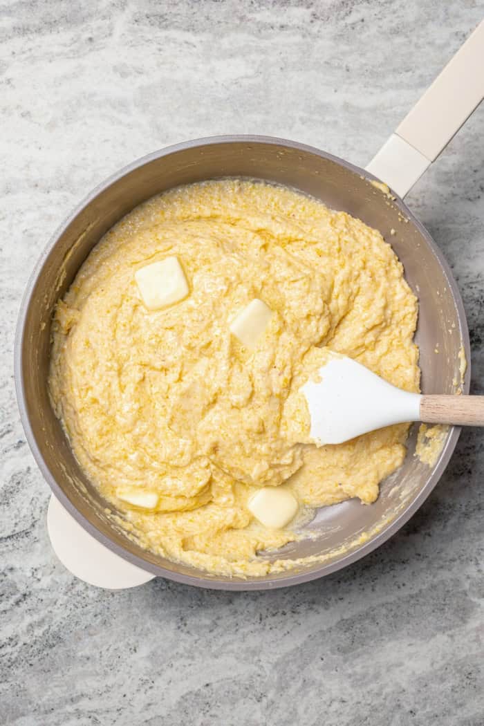 This Southern Spoon Bread recipe is fluffy, soft and lightly sweet, like a cross between cornbread and soufflé. A perfect holiday side dish! Stirring butter into cornmeal mixture in skillet.