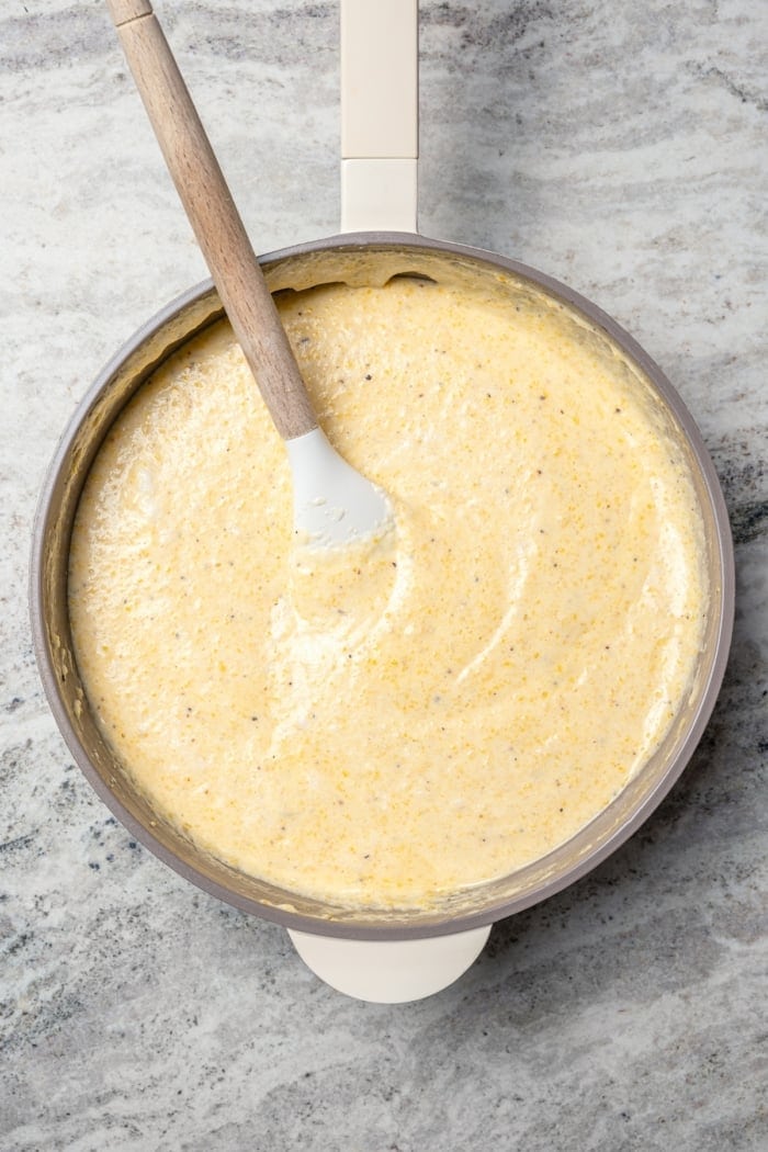 Spoon stirring spoon bread mixture in skillet.
