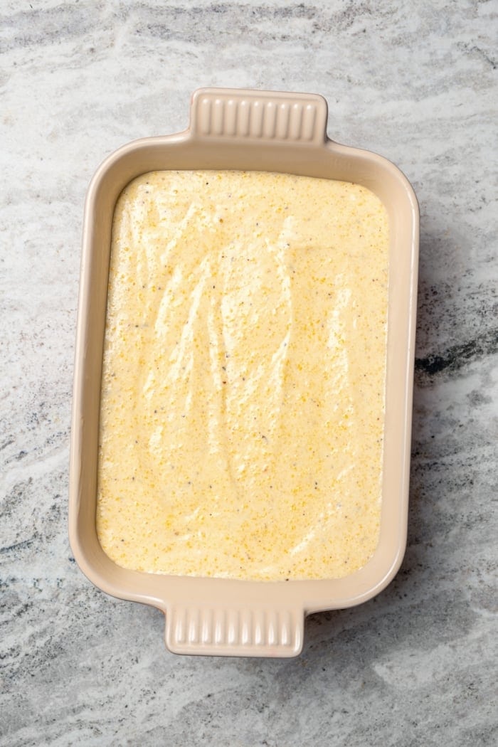 This Southern Spoon Bread recipe is fluffy, soft and lightly sweet, like a cross between cornbread and soufflé. A perfect holiday side dish! Unbaked spoon bread in casserole dish.