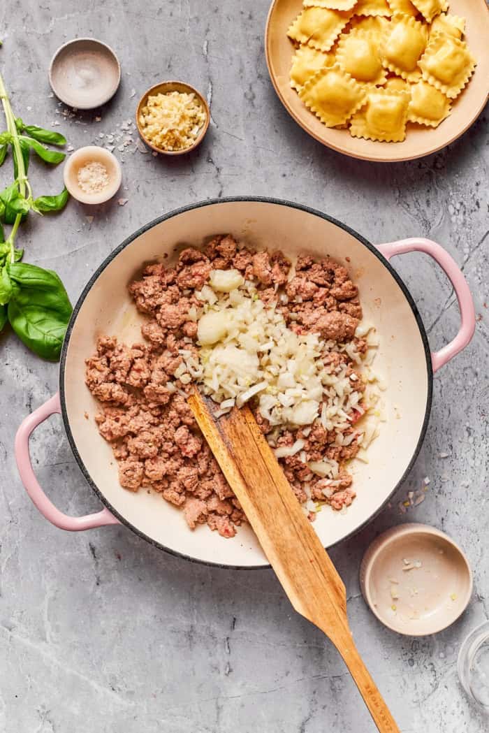 With a hearty meat sauce and plenty of cheese, this Lazy Ravioli Lasagna recipe delivers the flavor of the classic without the fuss! Onion added to ground beef in pan.