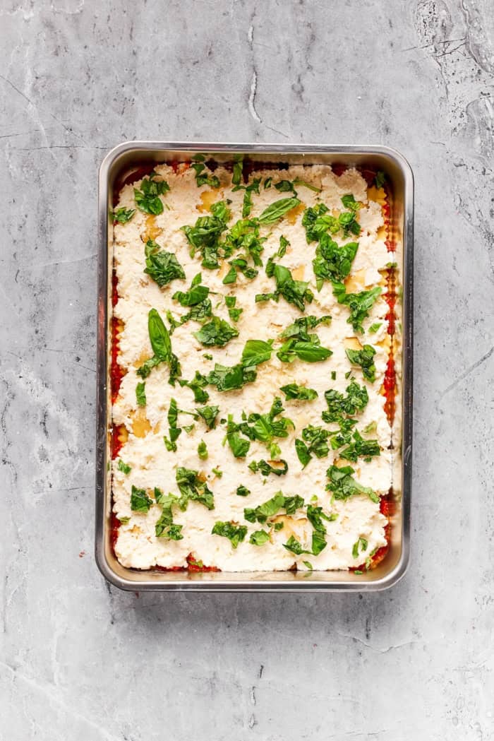 Basil added to pan for ravioli lasagna.