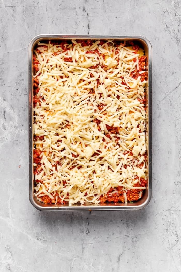 Ravioli lasagna with shredded cheese on top.