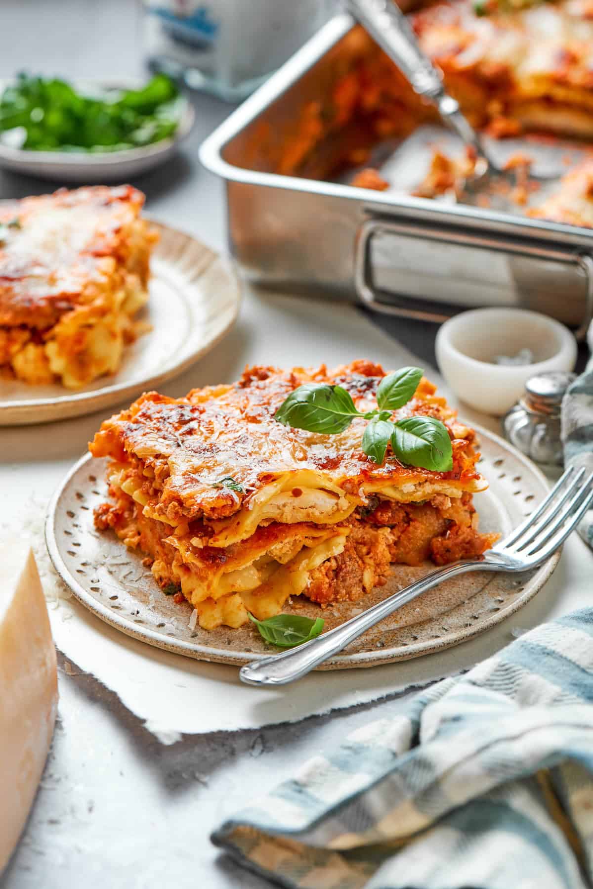With a hearty meat sauce and plenty of cheese, this Lazy Ravioli Lasagna recipe delivers the flavor of the classic without the fuss! Slice of ravioli lasagna on plate with fork.