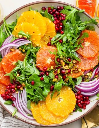 overhead photo of a winter salad with fresh citrus slices and pomegranate arils