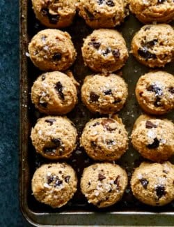 overhead photo of scoops of peanut butter chocolate chip cookie dough on a rimmed sheet pan