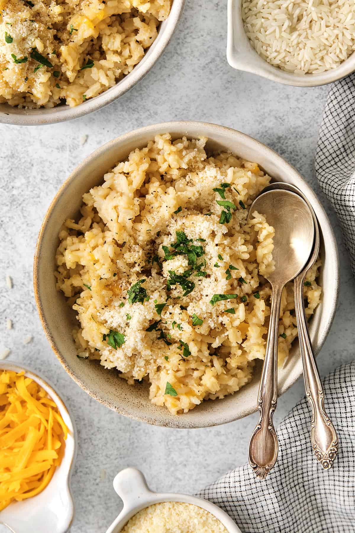 Bowl of cheesy rice with two spoons.