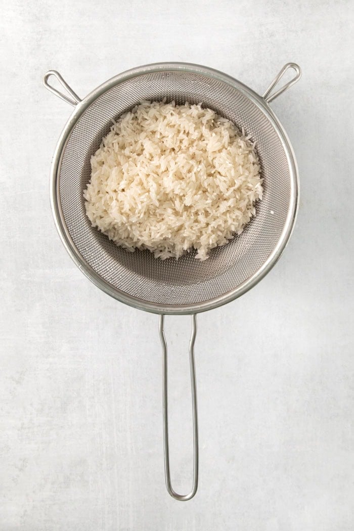 Long grain white rice in colander.