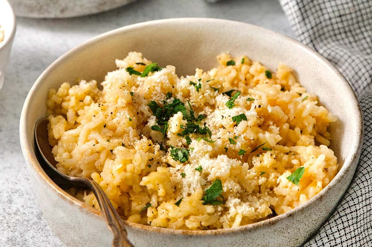 Spoon in bowl of cheesy rice.