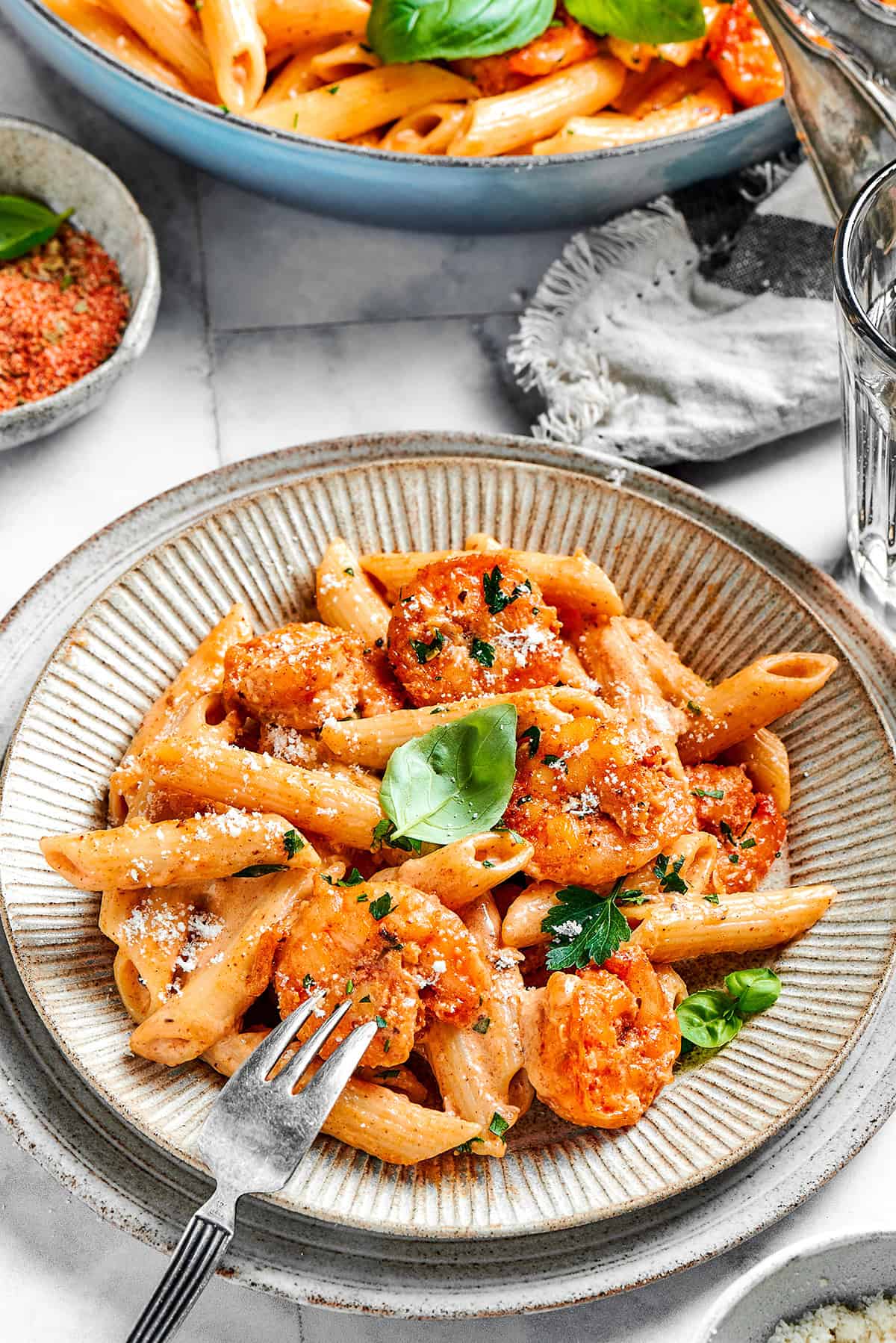 This beautiful, smoky-spicy Cajun Shrimp Pasta recipe folds juicy shrimp into a creamy, Louisiana-inspired sauce. an individual serving of Cajun shrimp pasta on an earth-toned plate