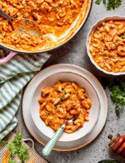 a pot of hamburger helper and two single servings in bowls