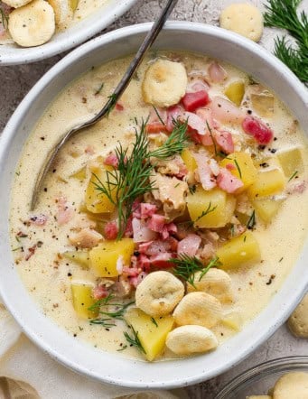 overhead photo of clam chowder with pork belly in a white bowl