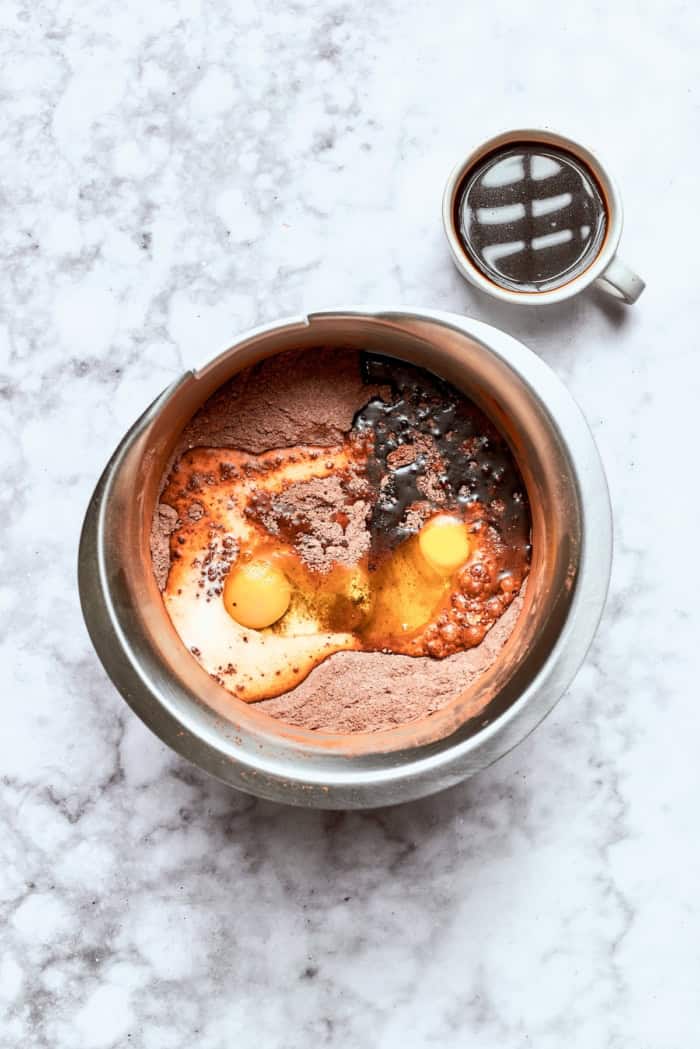 Chocolate cake with mint buttercream is perfect for any occasion. With fluffy mint frosting flecked with chocolate, it's such a crowd-pleaser! wet ingredients added to chocolate cake ingredients in a stainless steel mixing bowl