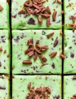 close-up overhead photo of mint chocolate chip buttercream on cake that is cut into square pieces