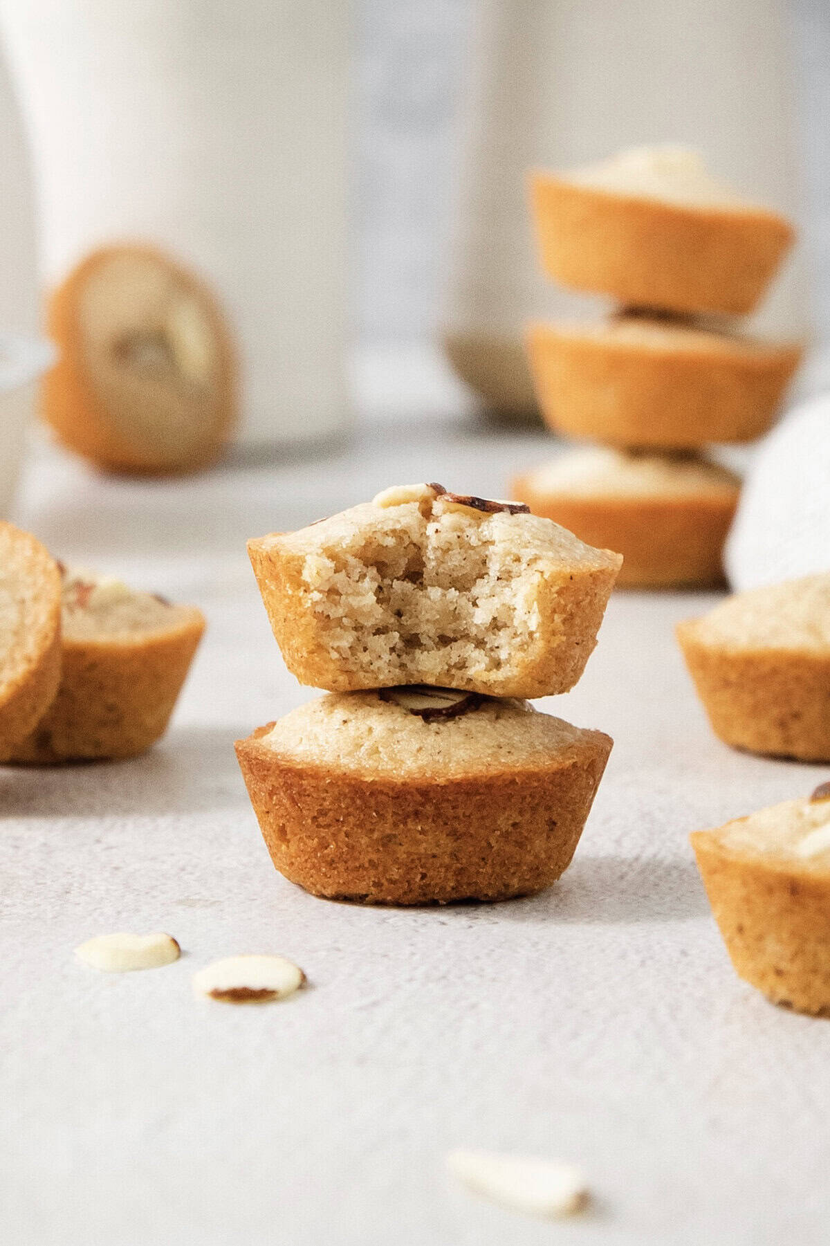 Financiers are an elegant treat that feels straight from a French bakery! My version is made in a muffin pan, so it's easy for home bakers. Stack of two financiers, with top one bitten to show tender crumb.