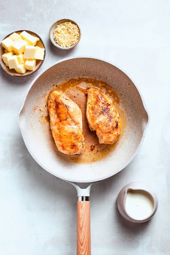 This chicken fettuccine Alfredo pairs chewy pasta with a garlicky Parmesan cream sauce and pan-fried chicken for a restaurant-worthy meal. Chicken breasts pan-fried in skillet.