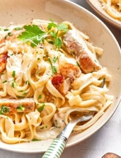 Bowl of chicken fettuccine alfredo with fork.