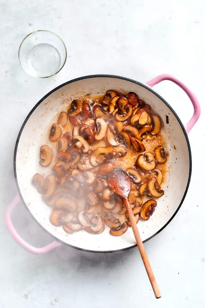 Browning mushrooms in pan.