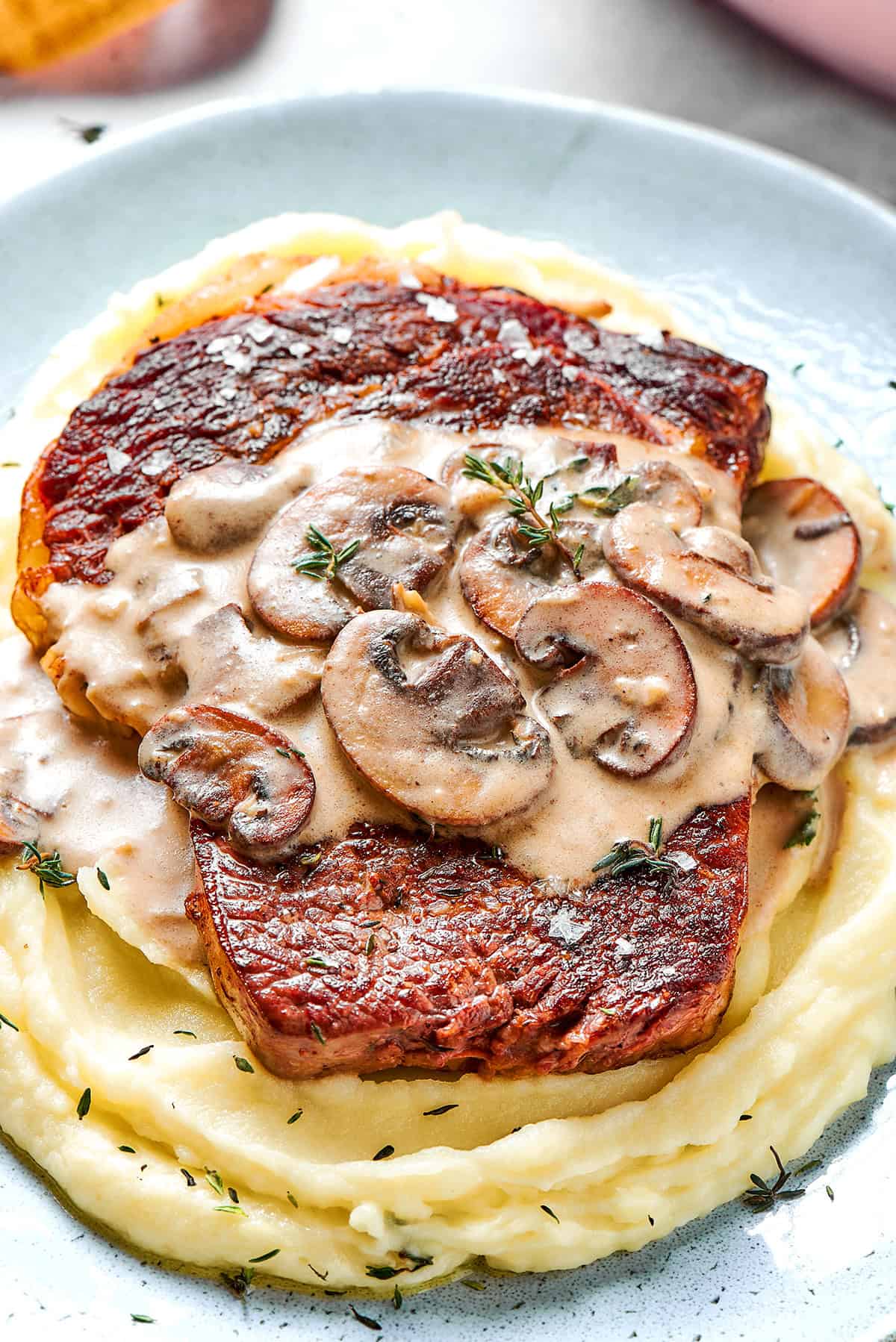 creamy mushroom sauce over a cooked steak on top of mashed potatoes