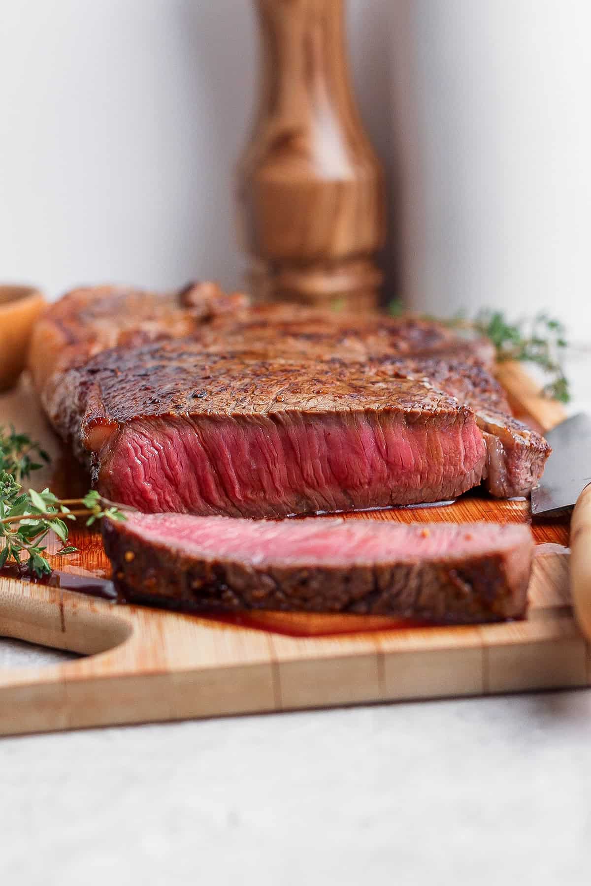This cast iron skillet steak is tender and perfectly seared, with a rich garlic butter finish. The best way to cook steak on the stovetop! Cast iron skillet steak sliced on cutting board.