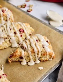 baked rhubarb scones with glaze, on a baking sheet with parchment paper
