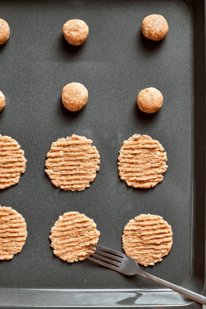These thin, crispy oat cookies are buttery and golden on the edges, with the most delightful crunch. Made with simple pantry ingredients! Fork set next to unbaked cookies on pan.