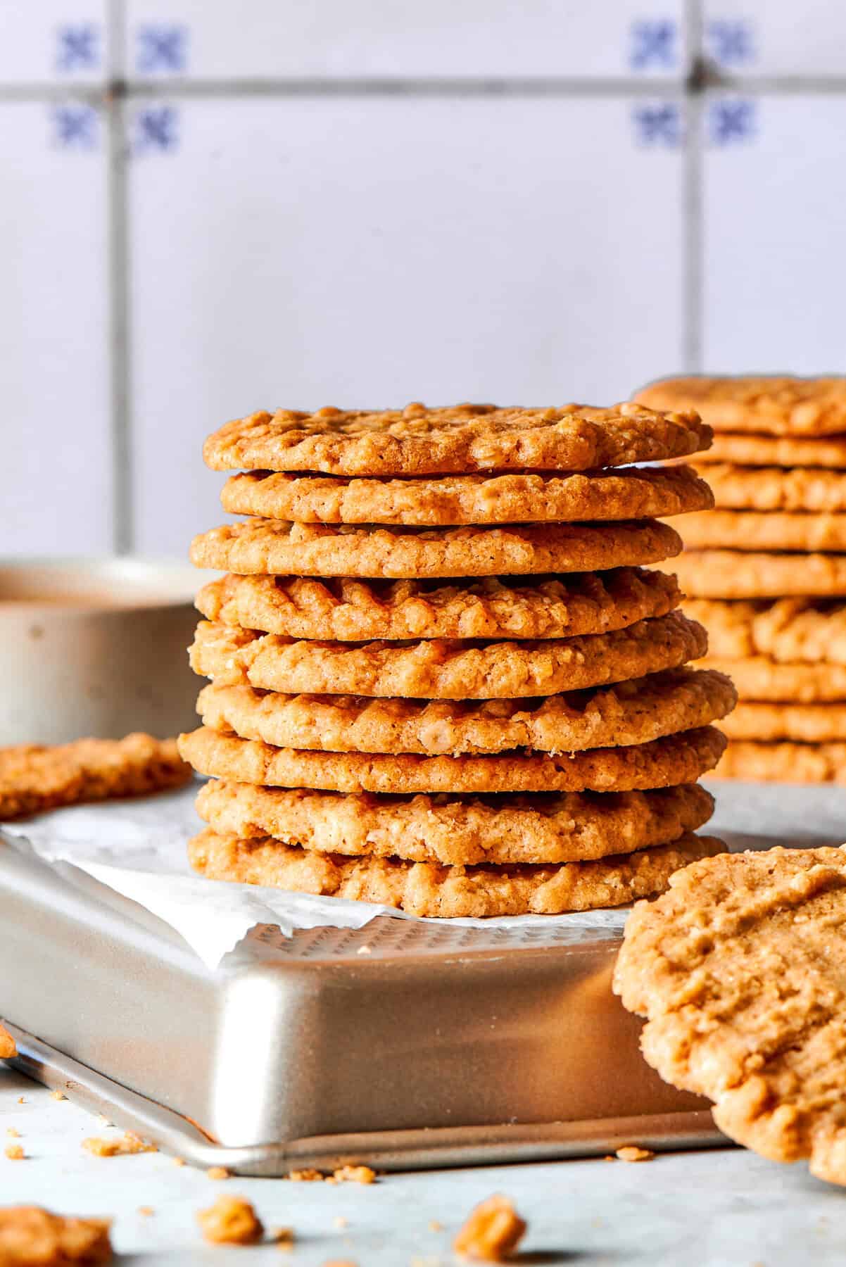 These thin, crispy oat cookies are buttery and golden on the edges, with the most delightful crunch. Made with simple pantry ingredients! Side photo of a stack of very thin oat cookies