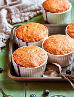 mini blueberry cobblers in ramekins, on a rimmed sheet pan