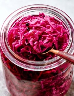 a spoon in a jar of pickled red cabbage
